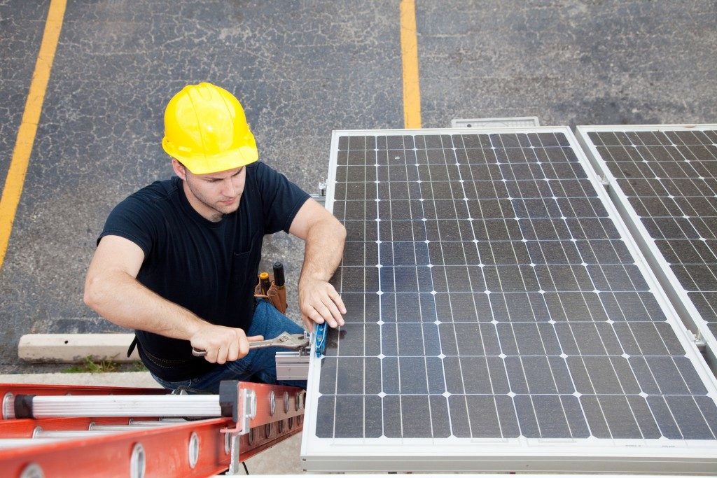 a blue collar worker installing a solar panel
