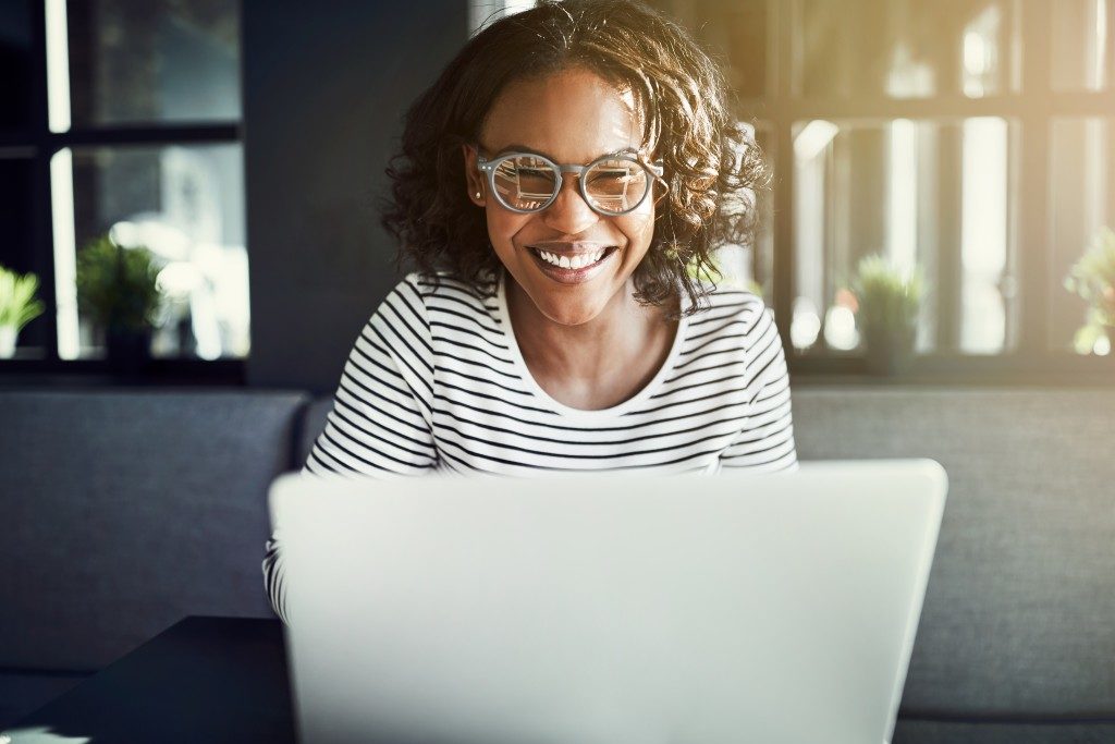 woman smiling in front of her laptop
