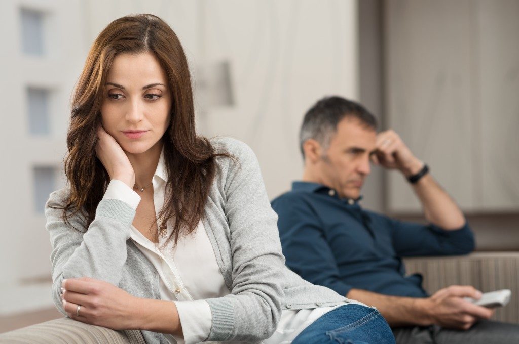 unhappy woman sitting beside her husband