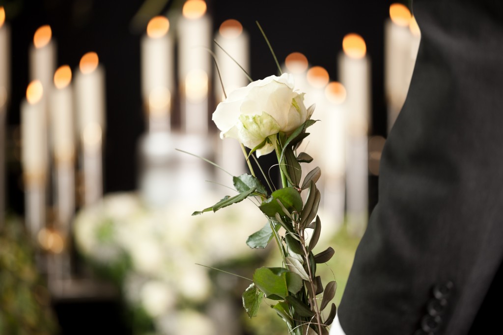 Man about to offer a rose in the burial