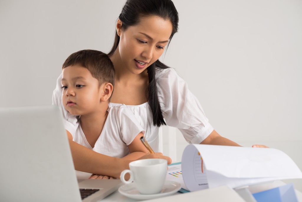 mom working while taking care of child