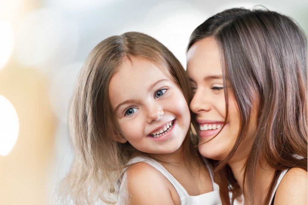 mother cuddling her daughter